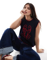 Woman wearing a navy sleeveless top with a red lobster design and blue jeans